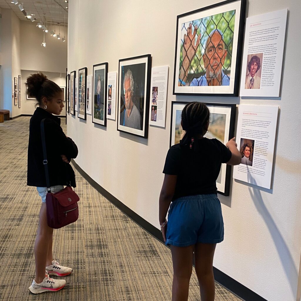 Two young girls looking at Portraits of Dementia.